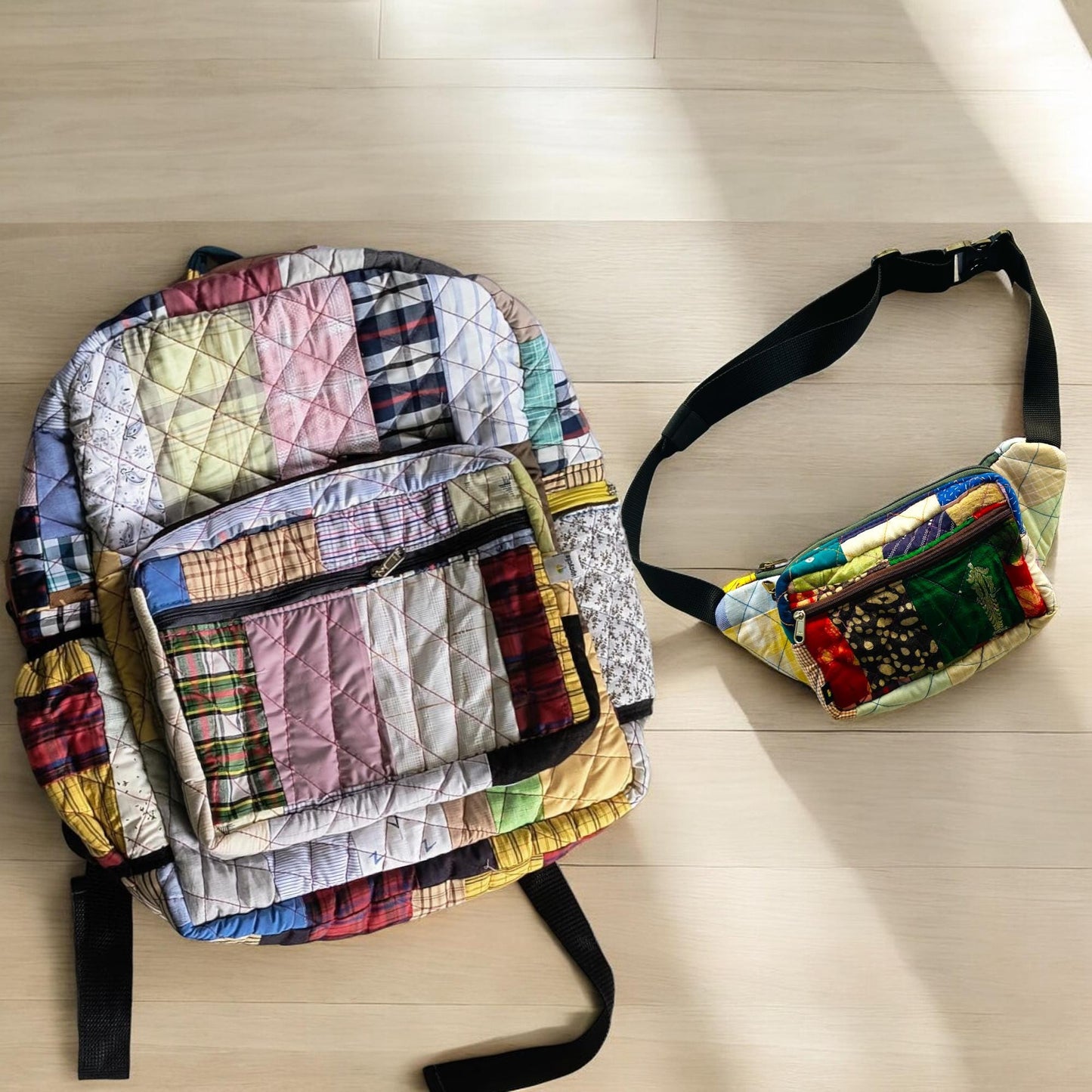 Multicolored upcycled patchwork backpack with coordinated fanny pack on a sunlit wooden floor. The vibrant fabrics feature plaid and block patterns, with quilted texture and durable zippers. Perfect as a travel set for eco-conscious adventurers. Great for gifting, festivals, or daily errands. A zero-waste fashion solution crafted by artisans using tailoring extras saved from landfill.