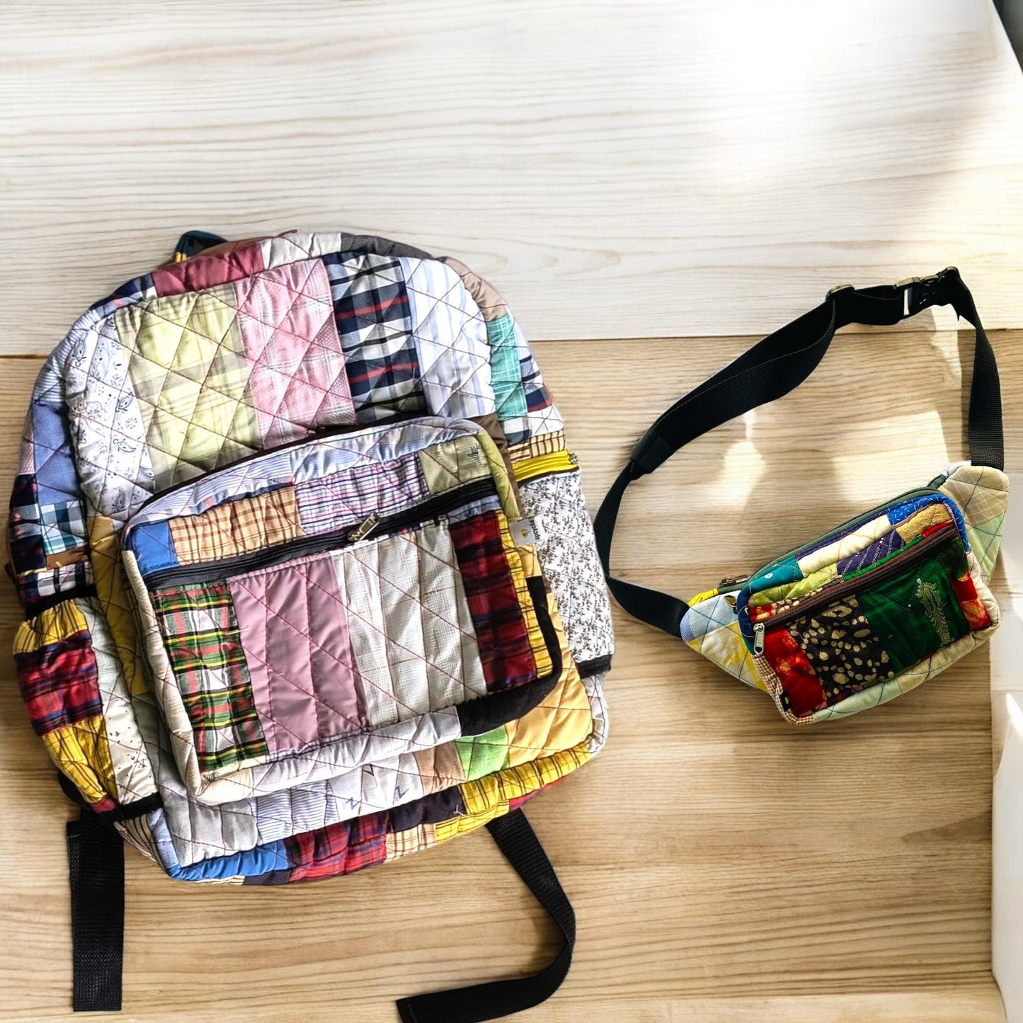 Upcycled patchwork backpack and fanny pack placed under sunlight on a clean wooden floor. The fanny pack features bright green and red blocks with Indian textile motifs, and a sturdy belt strap. Ideal as a festival, cycling, or walking companion. Sustainable and handmade, this versatile set offers a bold, stylish, and functional zero-waste alternative for everyday use.
