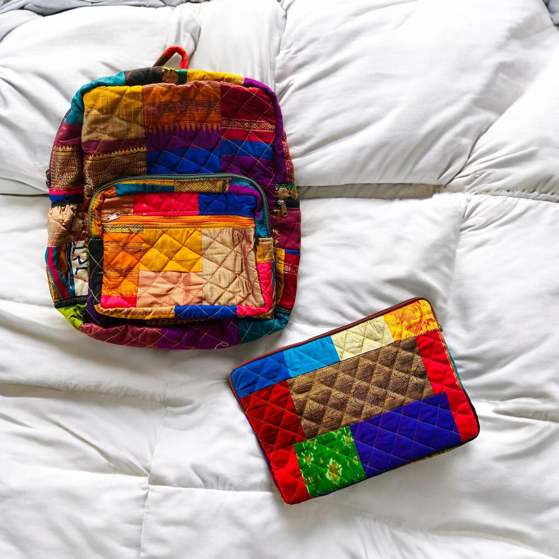 Backpack and padded laptop sleeve placed on a wooden floor. The MacBook is partially inserted into the sleeve, highlighting its snug fit and functional use. Both accessories feature eco-friendly, handmade patchwork crafted from upcycled cotton fabric. Ideal for gifting, school, or remote work. A sustainable, zero-waste solution for creative users who love bold, colorful designs. this showcases the Indian Weave pattern of laptop sleeve and backpack